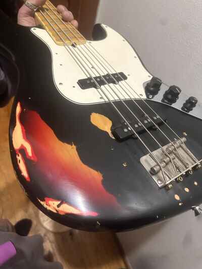 1975 Fender Jazz Bass black overspray over Sunburst factory painted that way.